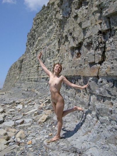 Nude Happy Girl Near A Wall Of Rocks