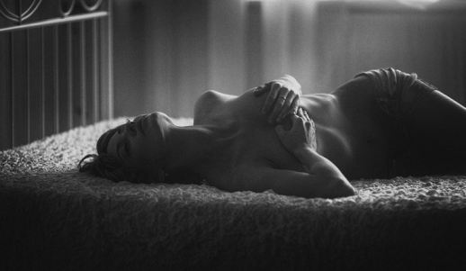 Nude Model In Bed Holding Boobs