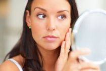 Woman Looking In Mirror At Face